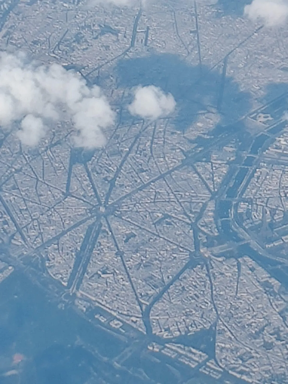 This is Paris. Taken through the window of a Boeing 737 at 39000 feet. The Arc de Triomphe and The Eiffel Tower are visible
