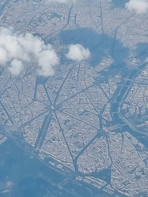 This is Paris. Taken through the window of a Boeing 737 at 39000 feet. The Arc de Triomphe and The Eiffel Tower are visible