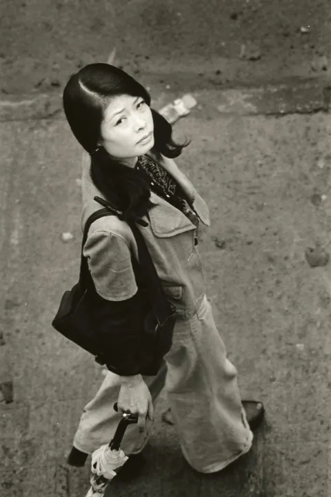 In 1974, Masahisa Fukase photographed his wife, Yōko Wanibe, every morning from the window of their apartment in Tokyo as she left for work.