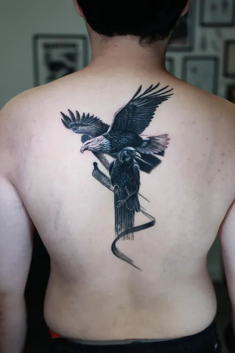 Black &amp; grey realism cover-up — turning a solid cross into an eagle &amp; raven composition (Mr. T • Los Angeles, CA)
