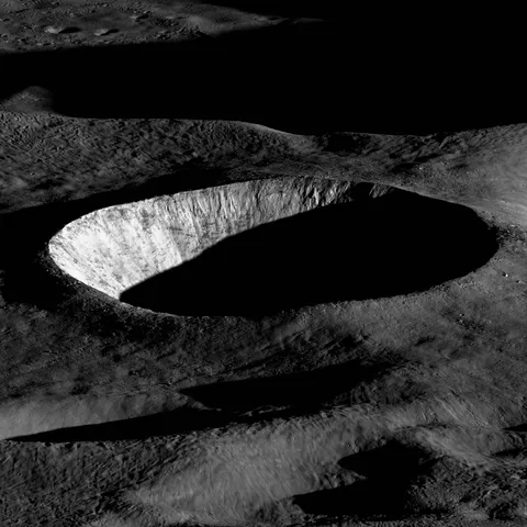 Early morning Sun illuminates the steep western wall of an unnamed 10-kilometer diameter crater on the Moon.  Imaged by the LRO.