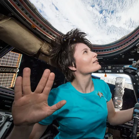 Astronaut Samantha Cristoforetti, on the International Space Station, wearing a Star Trek shirt and giving the Vulcan salutation
