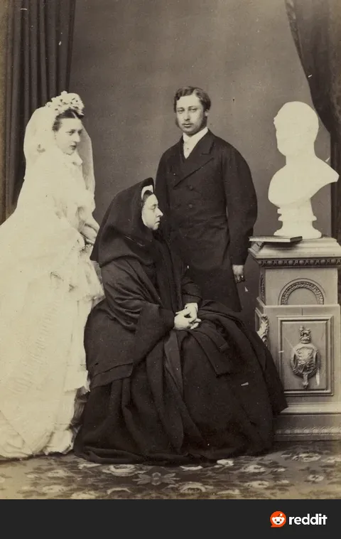 Queen Victoria photobombing her son's wedding photo by sitting between them wearing full mourning dress and staring at a bust of her dead husband, 1863