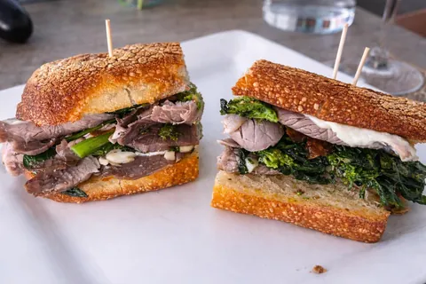 [homemade] thinly sliced slow roasted pork with sautéed broccoli rabe, garlic, melted provolone, mayo on a Semolina baguette 🥖