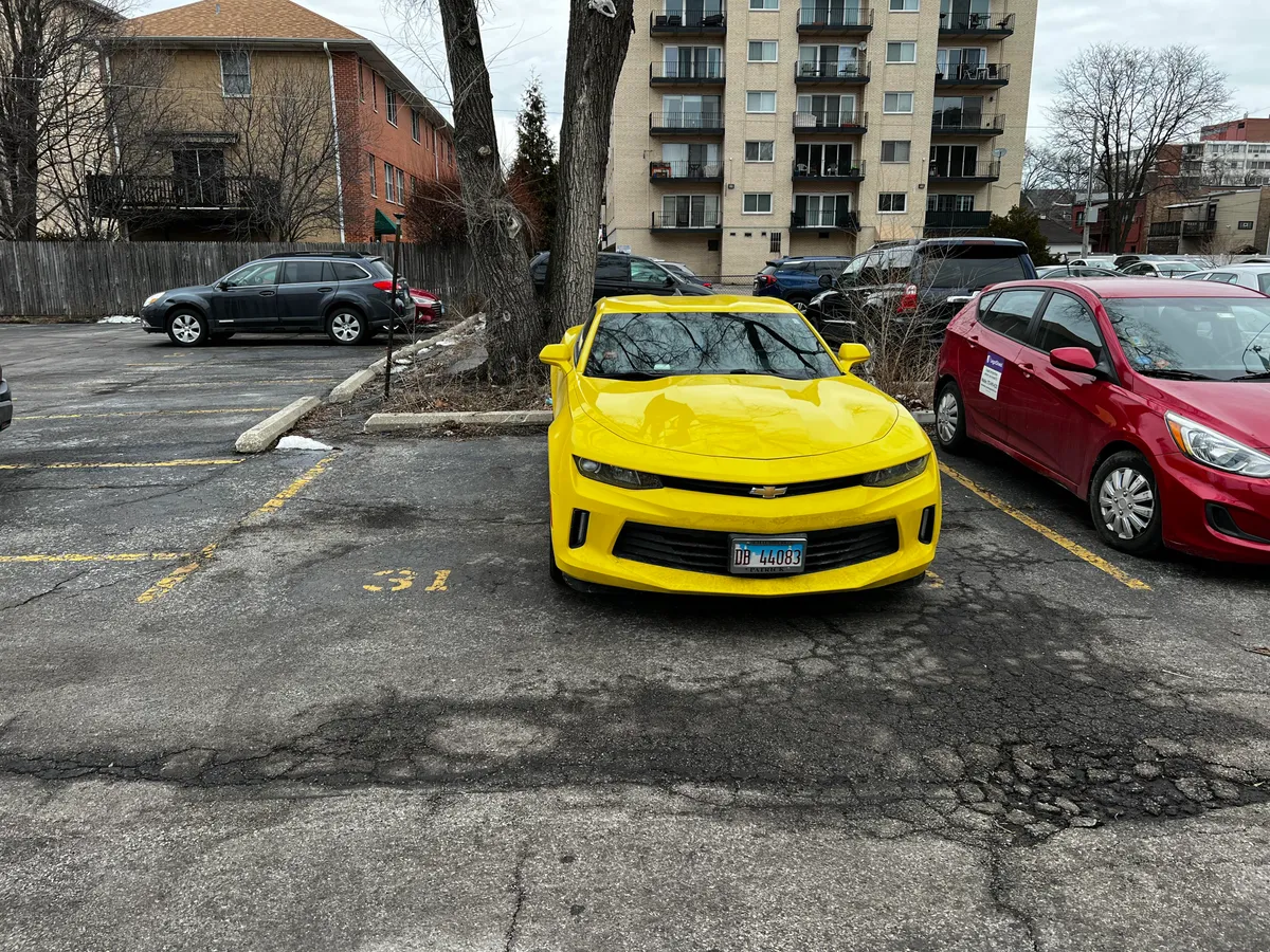 This person is double parked into my parking spot and I cant park my vehicle or I’ll block another spot next to me