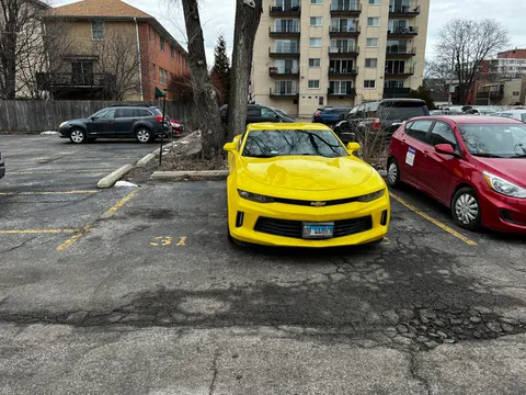 This person is double parked into my parking spot and I cant park my vehicle or I’ll block another spot next to me