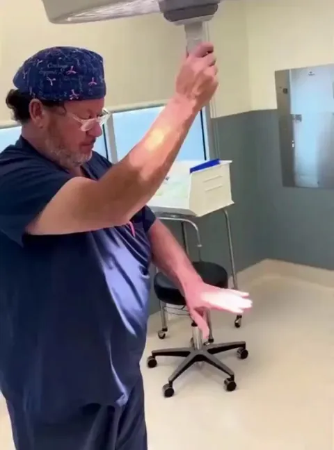 Doctor demonstrating how surgical lights are designed to eliminate shadows.