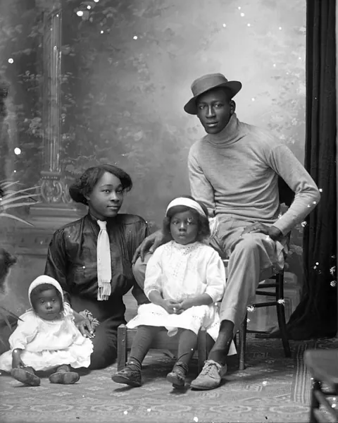 Family poses with their children for their professional studio photo, circa 1913. Glass negative