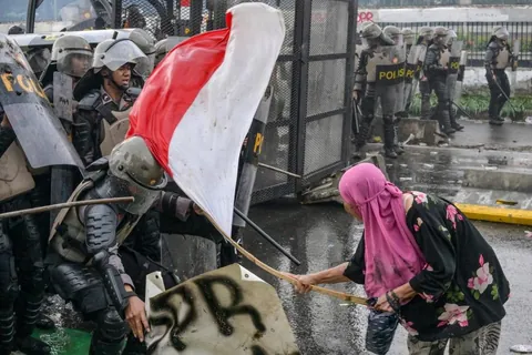 PsBattle: Lady hit police using flag during Jakarta riot