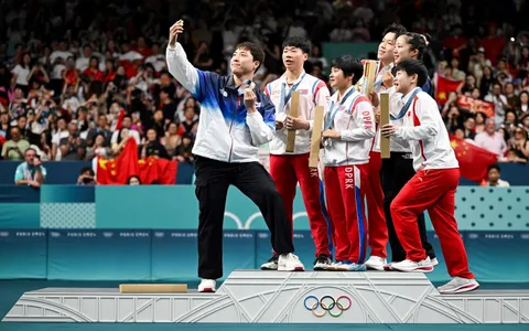 South Korean Olympian takes a selfie with North Korean athletes.