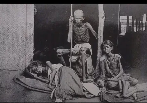 A man guards his family from cannibals during the Madras famine of 1877 under British rule in India.