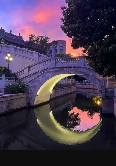 The lighting under the bridge gives an illusion of a crescent shaped moon in the water.