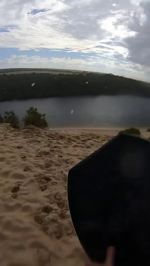 Man attempts to cross a river in Australia with a board by sliding down the hill