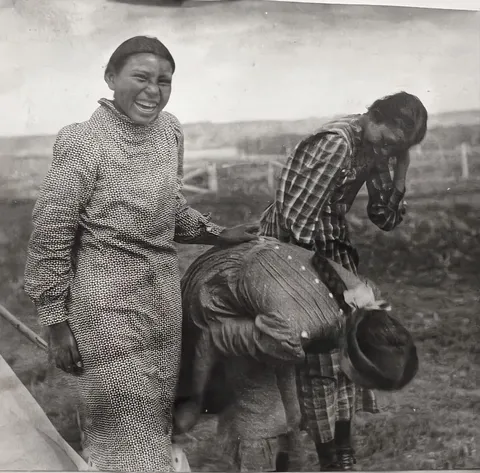 Three girls having a laugh in Fort Berthold Reservation, c. 1907. Photographed by Gilbert Livingstone Wilson, later repatriated to the Mandan, Hidatsa, Arikara Nation.