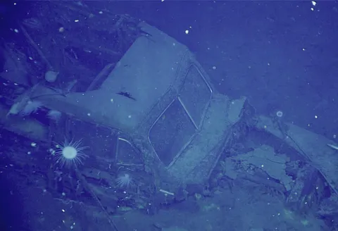 Three miles below the surface, A 1940-41 Ford Super Deluxe ‘Woody’ sitting in the deck of the sunken aircraft carrier USS Yorktown.