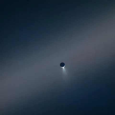 Enceladus, jetting water ice in front of Saturn's E-ring--captured by Cassini