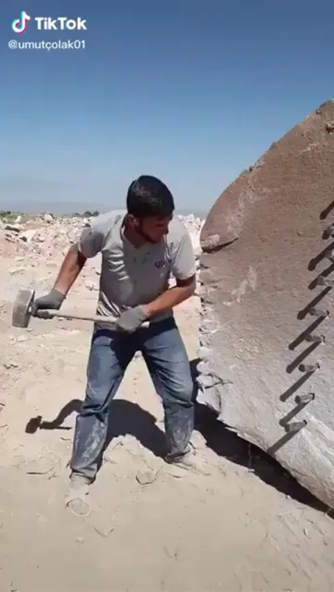 Man perfectly splitting huge rock with basic tools