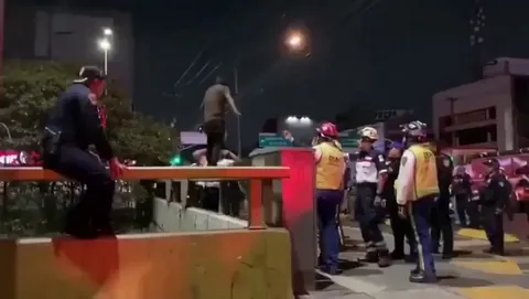 An emergency services worker in Mexico prevents someone's suicide attempt, on a bridge, with no safety equipment.