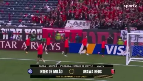 Urawa Red Diamonds fans salute their players as they enter the pitch for the pre-game warmup