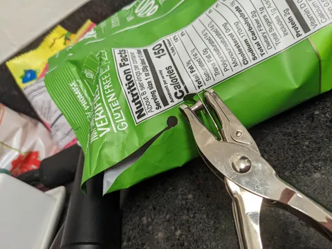 Accidentally tore the side of your bag of chips? Use a hole puncher to keep it from spreading.