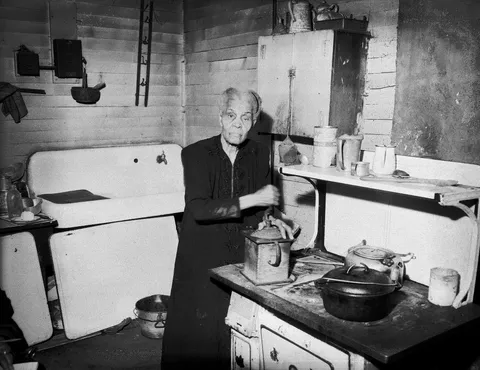 100 year old lady grinding coffee in her kitchen, Pitsburgh, April 1953