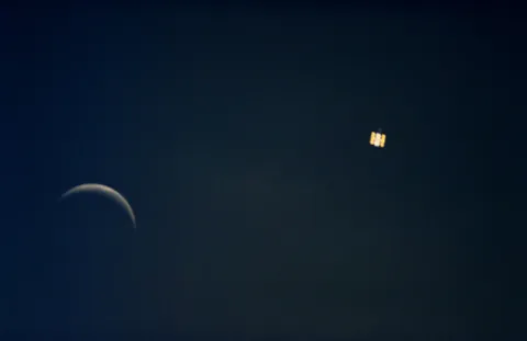 The "Earth-orbiting Hubble Space Telescope (HST) and the Moon" photographed from inside NASA's Space Shuttle Endeavour (STS-61) in December 1993. Photo credit: National Aeronautics and Space Administration (NASA)