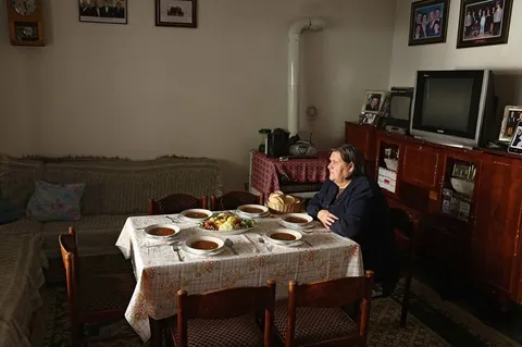 An old Albanian lady dining with her dead husband &amp; children who were killed in 1999 during the war