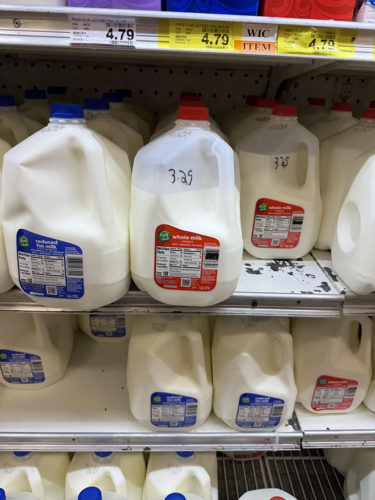 This grocery store is selling milk that is not all the way full at a discounted price.