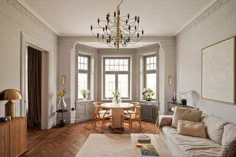 Bay window living room with ornate plasterwork and herringbone floors in a two-bedroom apartment in a 1903 building, Östermalm, central Stockholm, Sweden [1956x1304]
