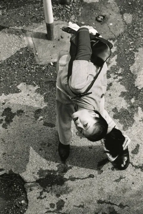 In 1974, Masahisa Fukase photographed his wife, Yōko Wanibe, every morning from the window of their apartment in Tokyo as she left for work.