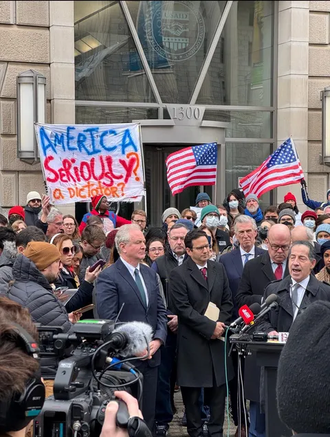 Congressmen and protesters outside the USAID