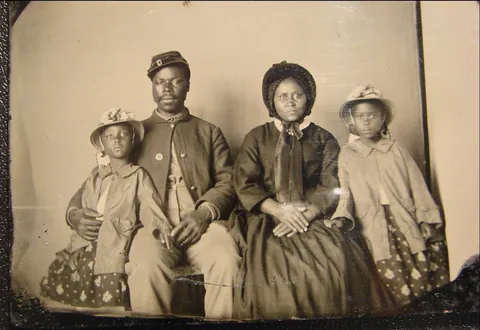 African american union soldier poses with wife and daughters, circa (1863)