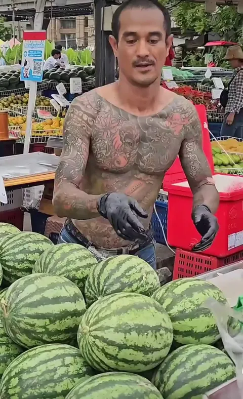 A tattooed man slices fresh Watermelon for you