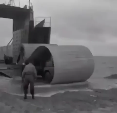 A Bedford RL ‘Bobbin’ truck from the 1950s lays a roadway mat on soft sand, making impossible beach landings smooth and fast