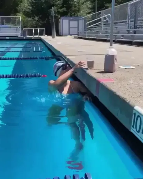 Olympic Gold Medalist, Katie Ledecky, swims with a glass of chocolate milk on her head