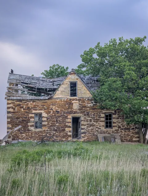 Decaying house with bird on roof