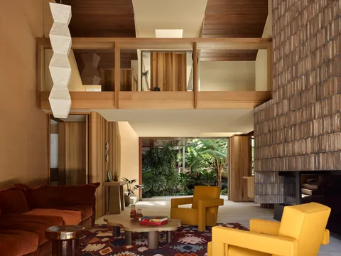 High ceiling living room clad with travertine, raw clay tile, cedar panelling and tobacco grass cloth in a renovated 1980s residence, North Shore, Northern Sydney, Australia [2000x1500]