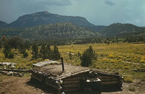 1940. Homesteaders Caudill Family sit down to dinner in their 'Dug-Out Home in Pie Town NM