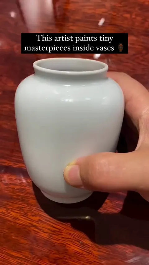 Artist Wan Li paints inside vases