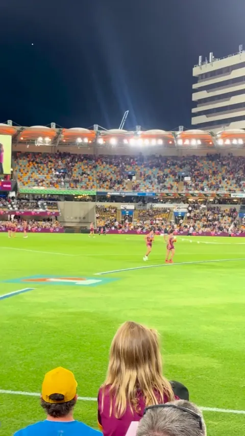 A kid pitch invades at an Australian Rules Football game and out runs security
