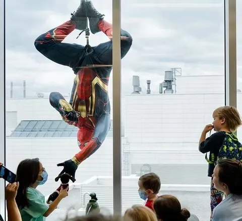 Tactical team personnel dressed up as Spiderman and Deadpool rappel down the walls of the Montreal Children's Hospital
