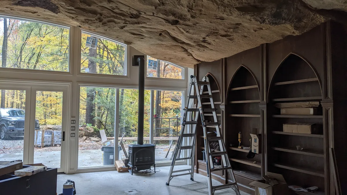 Is building under a huge rock like this safe? My first thought when I say this was earthquakes.