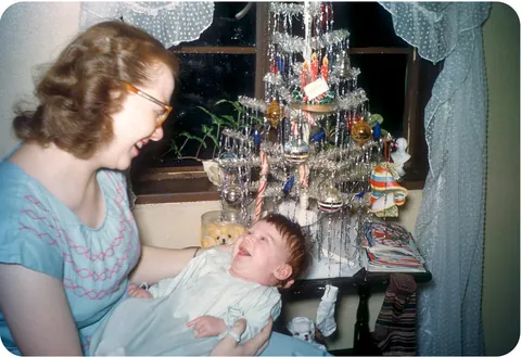 Mother gives her baby a bright smile and her baby answers with his own, 1950.