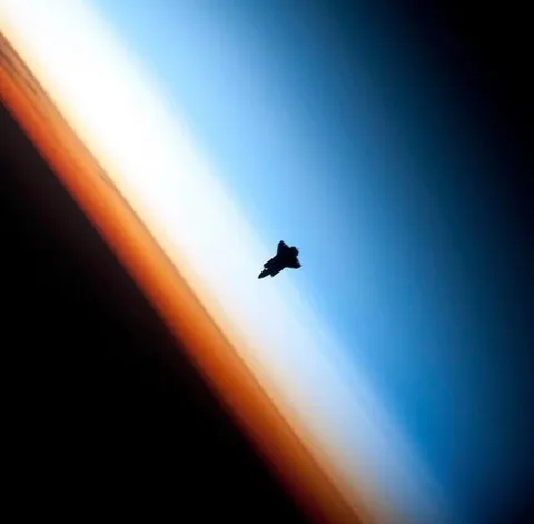 Silhouette of a Space Shuttle at Earth’s limb