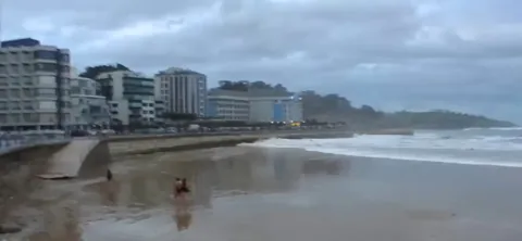 Dancing woman swept away by waves on beach