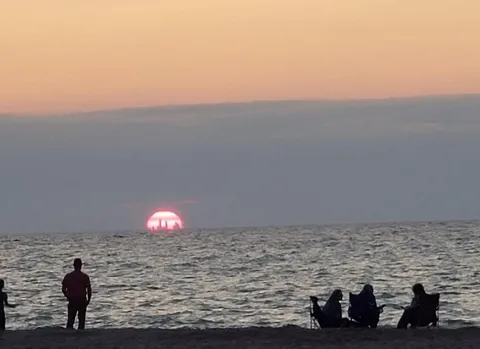 Chicago skyline visible from nearly 50 miles away in Indiana Dunes sunset.