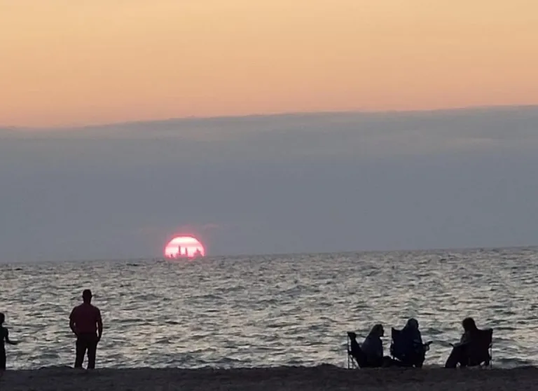 Chicago skyline visible from nearly 50 miles away in Indiana Dunes sunset.