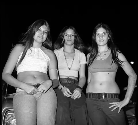 Timeless candid of friends posing for a shot, mid 1970s.