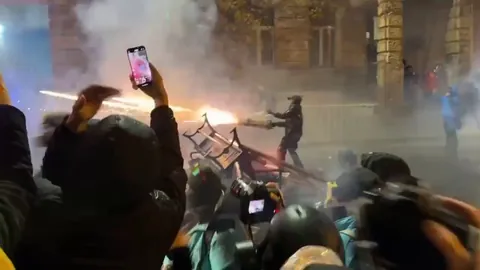Protesters in Georgia use fireworks against water cannon