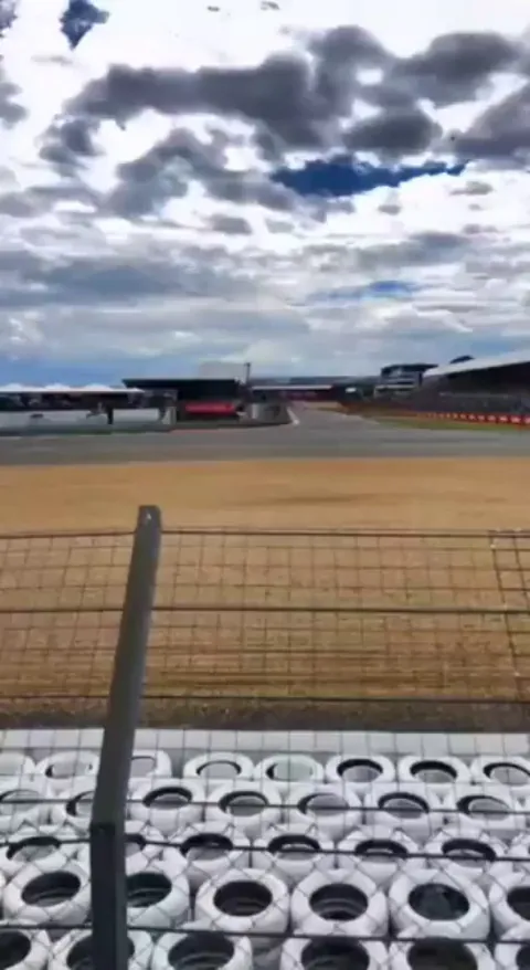 F1 car flips, clears a tire wall, and lands in the spectator fence right in front of them